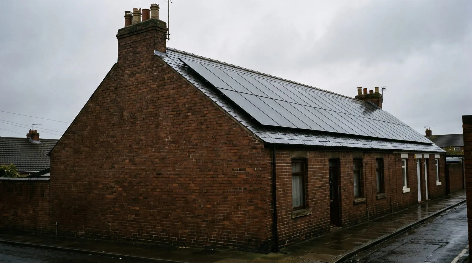 An end-terrace house with a long roof slope covered in solar panels
