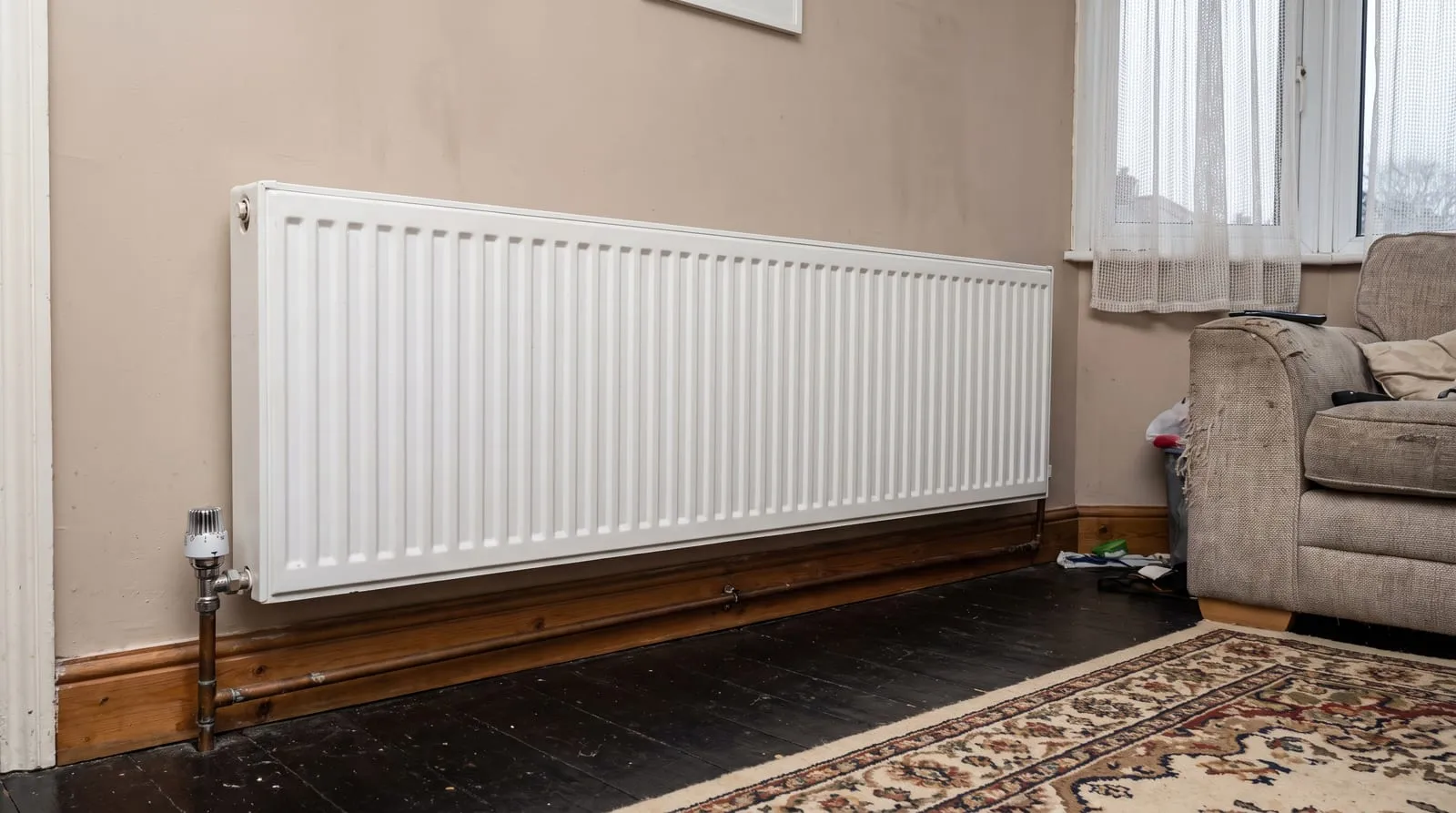 A white panel radiator under a living room window